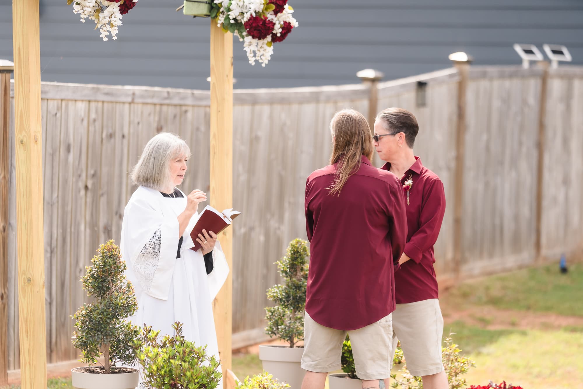 A wedding officiant leading an outdoor ceremony.
